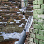 Broken frozen downspout with ice inside
