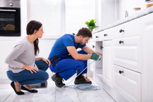 plumber working under sink