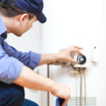 Plumber adjusting a hot-water heater