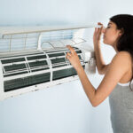 Woman Checking Air Conditioner