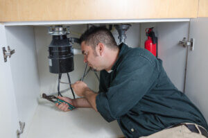 plumber fixing garbage disposal